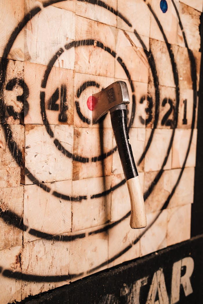 birthday-party-04 A dramatic close-up of an axe embedded in a wooden target, highlighting precision and skill in axe throwing.